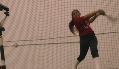 female softball player swinging bat